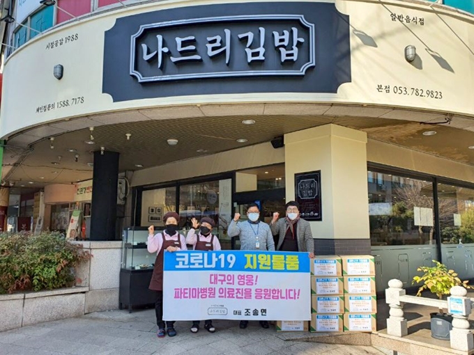 9일 대구 수성구 ‘나드리김밥 지산동 본점’ 임직원들이 파티마병원 의료진에게 전달할 김밥과 함께 응원의 구호를 외치고 있다. 나드리FS 제공