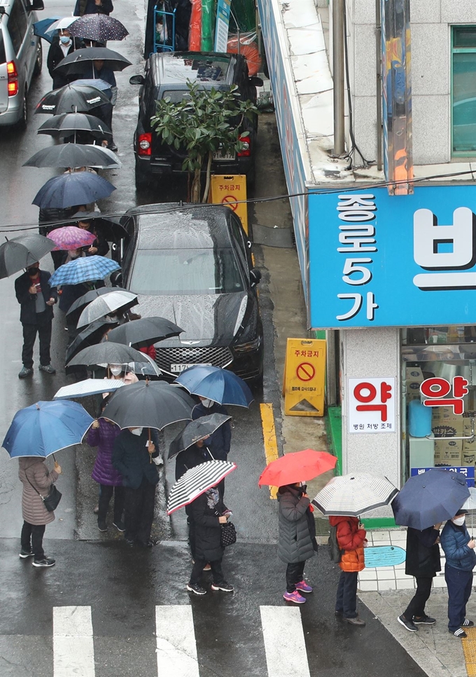 마스크 5부제 시행 이틀째인 10일 서울 종로5가 인근 한 약국에서 우산을 쓴 시민들이 공적 마스크 구매를 위해 줄을 서 있다. 마스크 5부제에 따라 출생연도 끝자리가 1과 6이면 월요일, 2와 7이면 화요일, 3과 8이면 수요일, 4와 9이면 목요일, 5와 0이면 금요일에 마스크를 살 수 있다. 연합뉴스