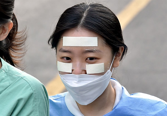 3일 코로나19 지역거점병원인 대구 중구 계명대학교 대구동산병원에서 근무 교대를 준비하는 의료진 얼굴에 마스크 및 고글 자국 방지를 위한 반창고가 붙어있다. 대구=뉴시스