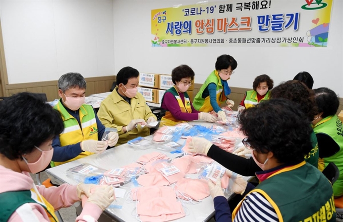 박용갑 대전 중구청장과 정난호 중구자원봉사센터장, 이옥화 중구자원봉사협의회장 등이 10일 중촌동 맞춤패션특화거리 상점가 상인회(회장 김옥희)에서 자원봉사자들과 함께 수제 마스크를 포장하고 있다. 대전 중구 제공