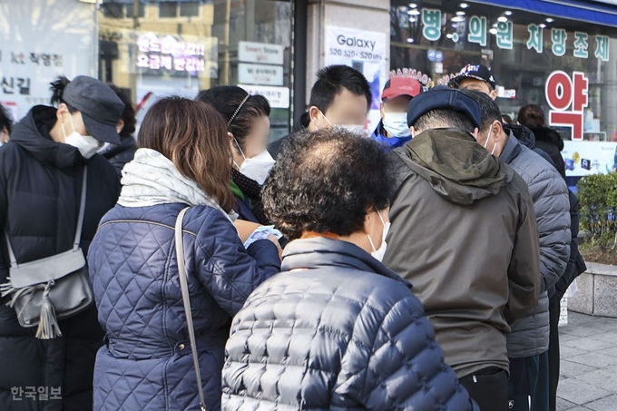 공적판매 마스크 5부제가 시행된 첫날인 9일 오전 서울 영등포구 소재 약국에 마스크가 아직 입고되지 않아 이를 구매하지 못한 시민들이 약국 앞에서 개인 판매자로부터 마스크를 구매하고 있다. 판매자는 50장의 KF94 마스크를 장 당 1,500원에 판매했다. 이한호 기자