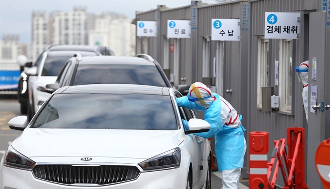 대구시 남구 대명동 영남대학교 병원 선별진료소에서 신종 코로나바이러스 감염증(코로나19) 검사를 받으러 온 시민들이 차에 탄 채 의료진으로부터 진료를 받고 있다. 연합뉴스