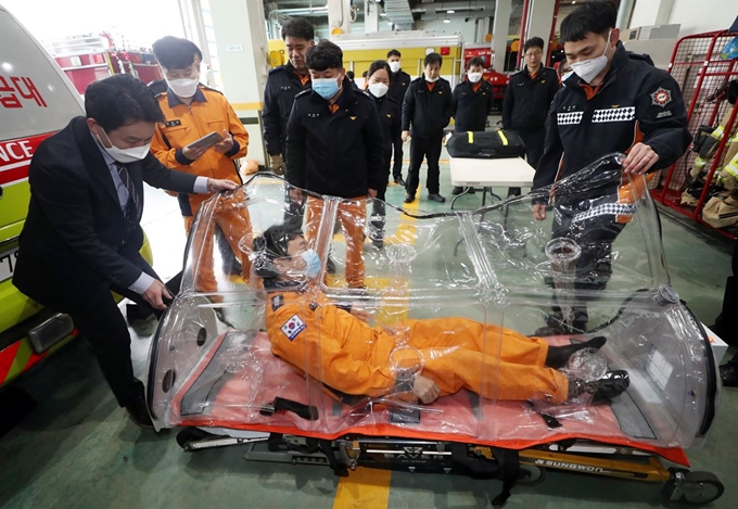 12일 오전 인천시 미추홀구 미추홀소방서에서 소방대원들이 '음압 이동형 들것'을 시연하고 있다. 이 장비는 신종 코로나바이러스 감염증(코로나19) 등 감염병 환자들을 병원으로 옮기는 데 사용된다. 연합뉴스