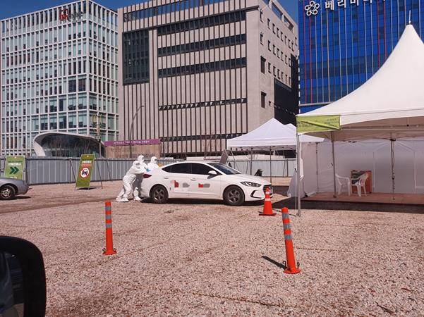 지난 11일 오전 서울 강서구 마곡8구역 드라이브 스루 선별진료소에서 의료진들이 고장 난 차량을 힘껏 밀고 있다.