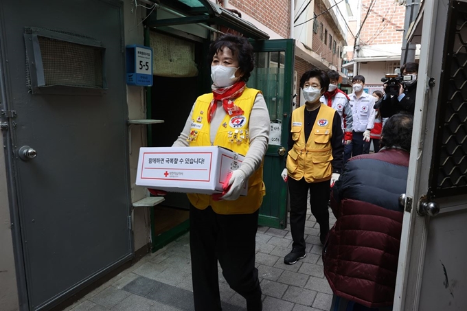 대한적십자사 서울지사 봉사원들과 직원들이 13일 낮 서울 종로구 돈의동 쪽방촌을 찾아 재난취약계층에 긴급구호품을 지원하고 있다. 서재훈 기자