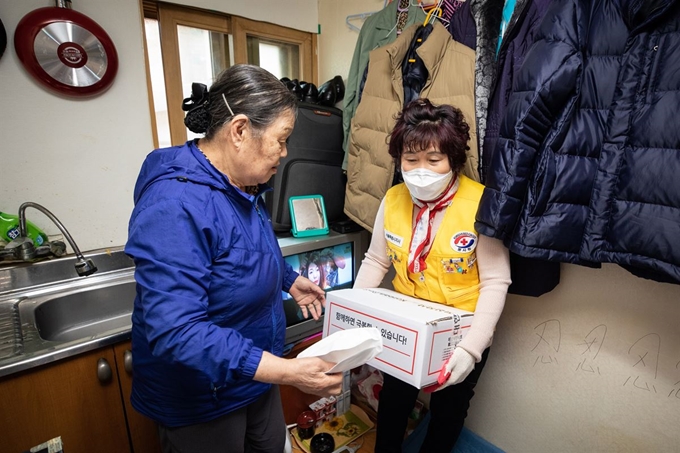 대한적십자사 관계자가 13일 서울 종로구 돈의동 쪽방촌을 찾아 재난 취약 계층의 코로나19 극복을 위해 긴급구호품을 전달하고 있다. 서재훈 기자