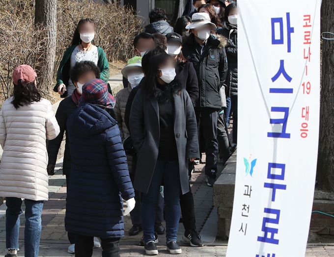 13일 오후 경기도 과천시 별양동 과천주공4단지에서 시민들이 무료로 나눠주는 마스크를 받기 위해 줄을 서 있다. 과천시는 재난관리기금 5천200여만원으로 방역 마스크 생산업체와 계약을 통해 5만8천300장의 마스크(KF94)를 확보했다. 마스크는 13일(오후 2∼8시)과 14일(오전 10시∼오후 6시) 이틀에 걸쳐 6개 동주민센터가 마련한 배부장소 16곳을 통해 모든 세대에 배부된다. 과천시에 주민등록을 둔 시민 5만8천253명이 대상이다. 연합뉴스