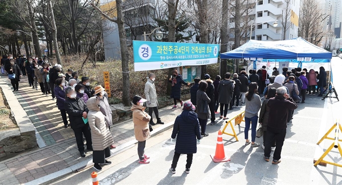 13일 오후 경기도 과천시 별양동 과천주공4단지에서 시민들이 무료로 나눠주는 마스크를 받기 위해 줄을 서 있다. 과천시는 재난관리기금 5천200여만원으로 방역 마스크 생산업체와 계약을 통해 5만8천300장의 마스크(KF94)를 확보했다. 마스크는 13일(오후 2∼8시)과 14일(오전 10시∼오후 6시) 이틀에 걸쳐 6개 동주민센터가 마련한 배부장소 16곳을 통해 모든 세대에 배부된다. 과천시에 주민등록을 둔 시민 5만8천253명이 대상이다. 연합뉴스