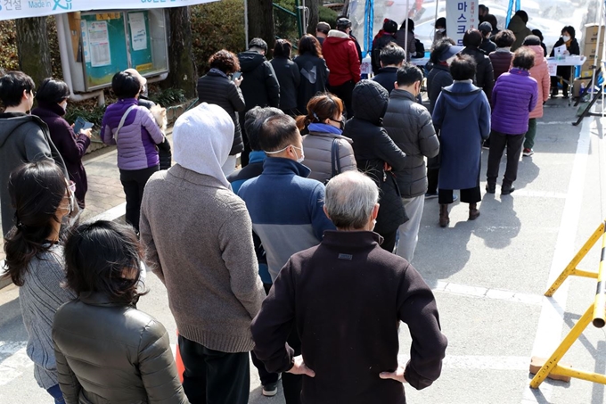 13일 오후 경기도 과천시 한 아파트에 설치된 마스크 무료 배부 장소에서 시민들이 마스크를 받기 위해 줄 서 있다.마스크는 13일(오후 2∼8시)과 14일(오전 10시∼오후 6시) 이틀에 걸쳐 6개 동주민센터가 마련한 배부장소 16곳을 통해 모든 세대에 배부될 예정이다. 뉴스1