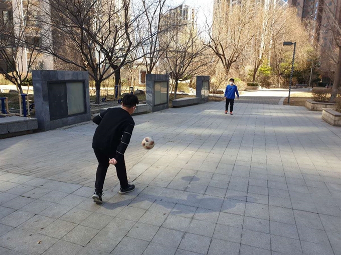 중국 베이징의 한 아파트 단지에서 아이들이 마스크를 낀 채 축구를 하고 있다. 신종 코로나바이러스 감염증 사태가 장기화하면서 개학을 한달 넘게 늦춘데다 단지를 벗어나 돌아다니는 건 감염 위험 때문에 꺼리다 보니 아이들은 온라인 수업을 마치고 나면 이런 식으로 스트레스를 해소하는 것 외에 달리 도리가 없다.