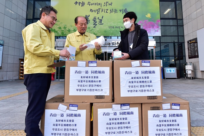 인천 부평구 관계자들이 지난 12일 중국 웨이하이시 원덩구에서 보내온 마스크를 살펴보고 있다. 부평구 제공