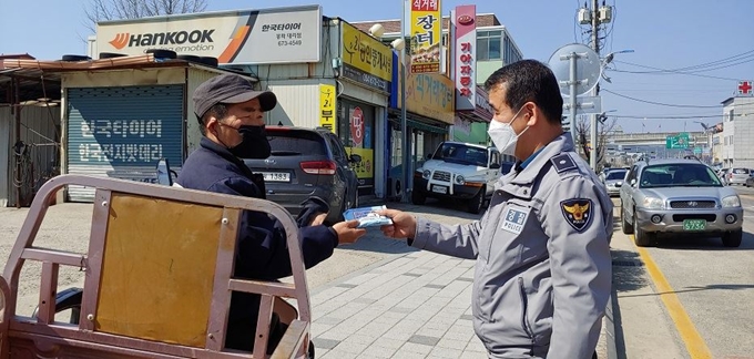 경북 봉화경찰서 교통경찰이 코로나19 예방기능이 있는 물티슈를 주민에게 건네며 교통사고 예방에 협조를 부탁하고 있다. 봉화경찰서 제공