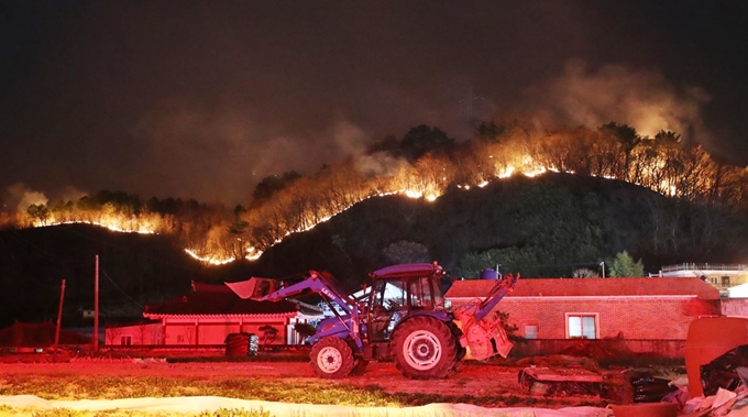 19일 오후 울산시 울주군에서 발생한 산불이 바람을 타고 번지면서 청량읍 삼정마을 인근 야산에까지 불길이 치솟고 있다. 연합뉴스