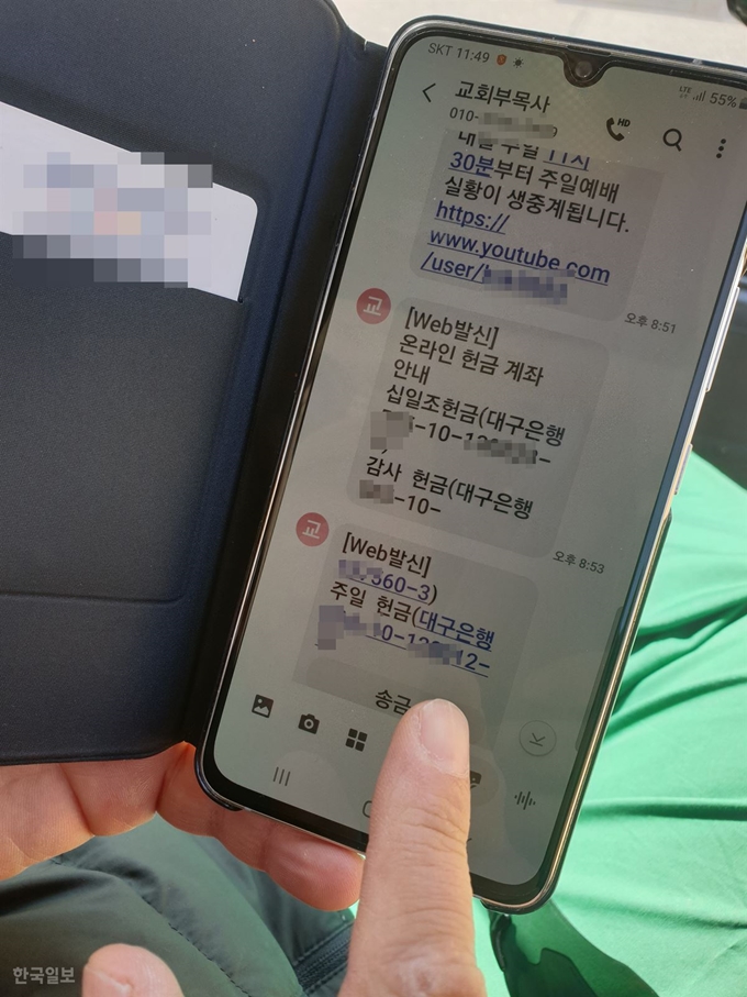 대구의 한 교회 신자가 휴대폰 문자메시로 날아온 교회 주일 헌금 통장 계좌를 보며 온라인 헌금 송금 버턴을 누르고 있다. 전준호 기자