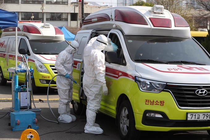 22일 오전 대구시 달서구 옛 두류정수장에서 119 구급대원이 신종 코로나바이러스 감염증(코로나19) 환자 이송에 투입된 119 앰뷸런스를 소독하고 있다. 대구·경북지역 코로나19 환자 이송을 위해 전국에서 집결한 119 앰뷸런스는 옛 두류정수장을 집결지로 삼고 환자이송을 하고 있다. 연합뉴스