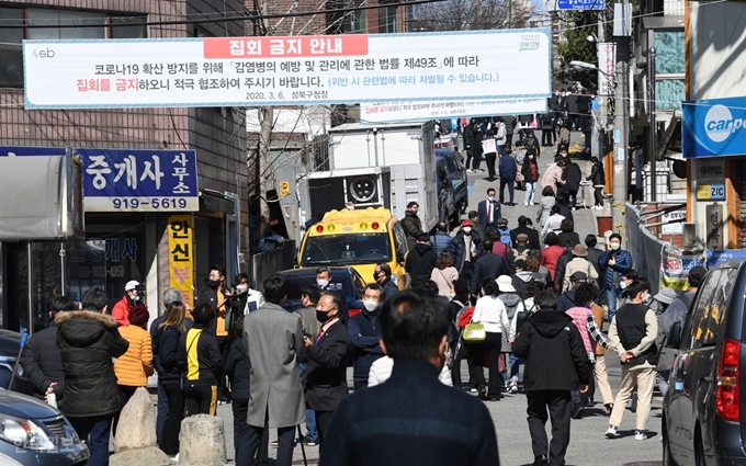 22일 오전 서울 성북구 소재 사랑제일교회로 이어지는 한 골목에 예배 참석을 위해 교회로 향하는 신도들과 이들을 취재하기 위해 나선 취재진으로 북적대고 있다. 그들 머리 위로 ‘집회 금지’ 현수막이 걸려 있다. 배우한 기자