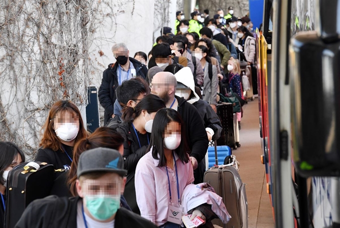 유럽에서 국내로 들어오는 입국자에 대한 검역 절차가 강화된 22일 오후 인천국제공항 1터미널에서 독일 프랑크푸르트발 여객기를 타고 입국한 승객들이 진단 검사를 받는 곳으로 이동하는 차량으로 향하고 있다. 연합뉴스