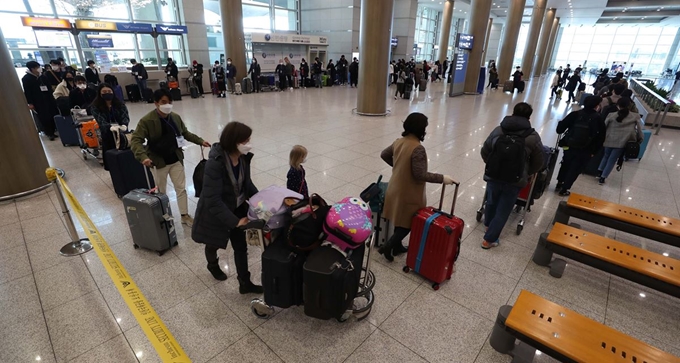 [200322 인천공항 11] 유럽 내 코로나19 확산으로 22일부터 유럽에서 국내로 들어오는 입국자에 대해 전수조사가 시행된다. 정부는 입국자의 격리와 검사를 위해 임시생활시설을 1천 실 규모로 운영할 계획이다. 22일 오후 인천국제공항 1터미널을 통해 독일 프랑크푸르트발 비행기 탑승객들이 입국하고 있다. /배우한 기자 2020-03-22(한국일보)