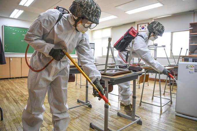 해병대 연평부대 부대원들이 지난 18일 인천시 옹진군 연평초등학교에서 코로나19 확산 방지를 위한 방역작업을 하고 있다. 해병대 제공