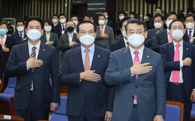 바른미래당을 탈당해 미래통합당에 합류한 임재훈(앞줄 오른쪽부터), 김중로, 이동섭 의원과 미래통합당 의원들이 지난달 26일 국회에서 열린 의원총회에서 마스크를 쓰고 국민의례하고 있다. 연합뉴스