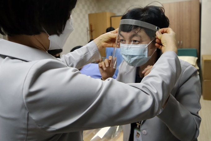 23일 오후 광주 동구 전남대학교에서 병원 관계자들이 코로나19 검체 검사시 의료진이 쉽고 가볍게 착용할 수 있는 감염방지용 안면보호대(face shield)를 자체 제작해 착용해보고 있다. 연합뉴스