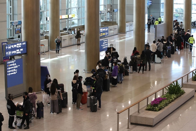 23일 오전 인천국제공항 1터미널에서 영국 런던발 여객기를 타고 입국한 승객들이 진단 검사를 받는 곳으로 향하는 차량으로 이동하고 있다. 연합뉴스