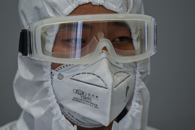 중국 상하이 푸동공항에서 26일 검역요원이 입국자 모니터를 살펴보고 있다. 상하이=AFP 연합뉴스