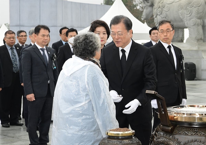 문재인 대통령이 27일 국립대전현충원에서 열린 서해수호의 날 기념식에서 분향하던 중 유가족의 질문을 듣고 있다.연합뉴스