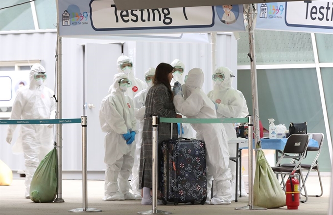 26일 오후 인천국제공항 1터미널 옥외공간에 설치된 개방형 선별진료소(오픈 워킹스루형·Open Walking Thru)에서 독일 프랑크푸르트발 여객기를 타고 입국한 무증상 외국인이 코로나19 진단검사를 받고 있다. 연합뉴스