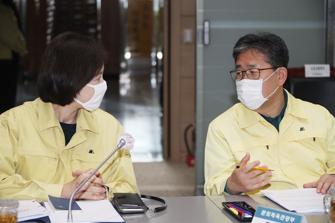 유은혜(왼쪽) 부총리 겸 교육부 장관과 박양우 문화체육관광부 장관이 지난 28일 정부서울청사 중앙재난안전상황실 서울상황센터에서 열린 신종 코로나바이러스 감염증(코로나19) 대응 중앙재난안전대책본부 회의에 참석해 대화하고 있다. 연합뉴스