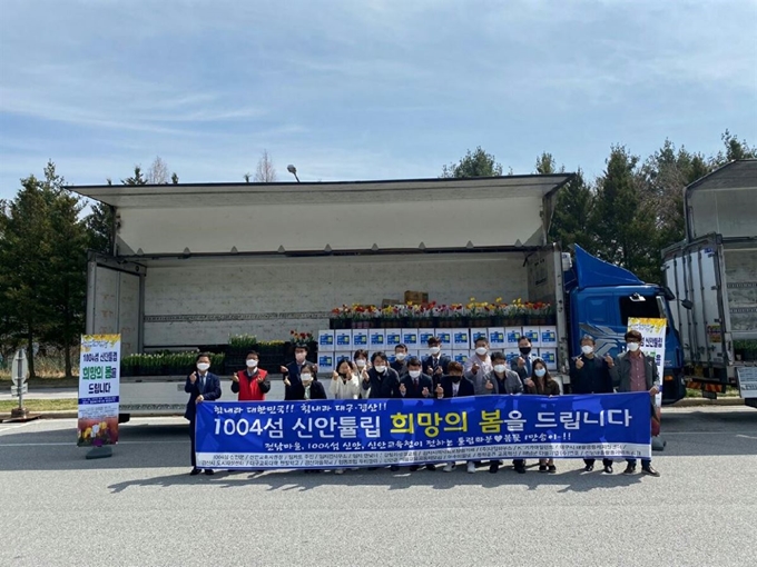 대구시와 신안군 관계자들이 31일 오후 지리산 휴게소에서 만나 '1004섬 신안튤립 희망의 봄' 튤립 꽃을 전달하고 있다. 신안교육청 제공