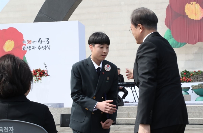 문재인 대통령이 3일 제주 4·3 평화공원에서 열린 '제72주년 제주 4·3 희생자 추념식'에서 편지를 낭독한 희생자 유족 김대호 군을 격려하고 있다. 제주=연합뉴스