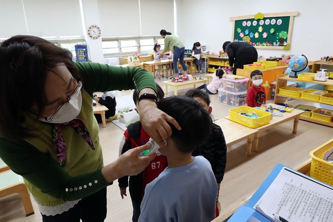 지난 30일 광주 서구 광천초병설유치원에서 긴급돌봄교실 교사가 원아 체온을 확인하고 있다. 광주=연합뉴스