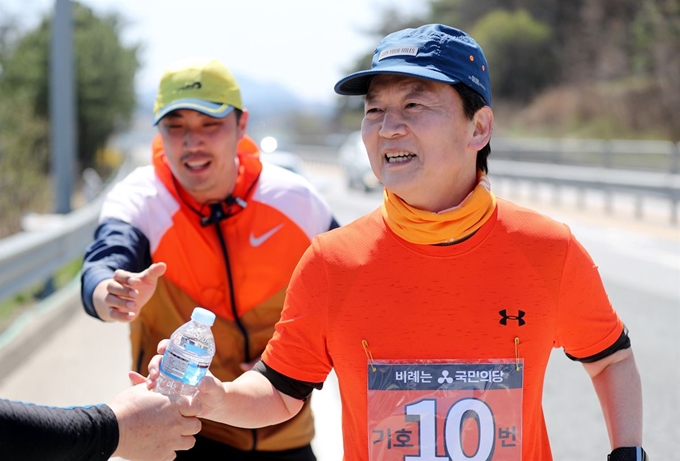 국민의당 안철수 대표가 5일 오후 전북 임실군에서 국도 17호선을 따라 달리던 중 지지자가 건네 준 물병을 받아 들고 있다. 안 대표는 ‘국난극복’, ‘지역감정 해소와 통합’, ‘정부 개혁과 약속의 정치’ 등을 주제로 지난 1일 전남 여수에서 출발해 수도권까지 하루 평균 30㎞가량 달리기로 이동하고 있다. 연합뉴스