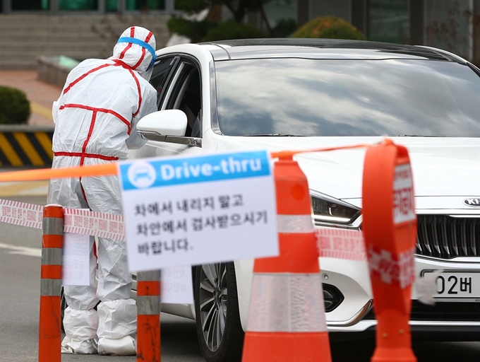 한 의료진이 대구 남구 영남대병원 속칭 ‘드라이브 스루’ 선별진료소에서 차량에 탑승한 시민을 상대로 신종 코로나바이러스 감염증(코로나19) 검사를 하고 있다. 연합뉴스