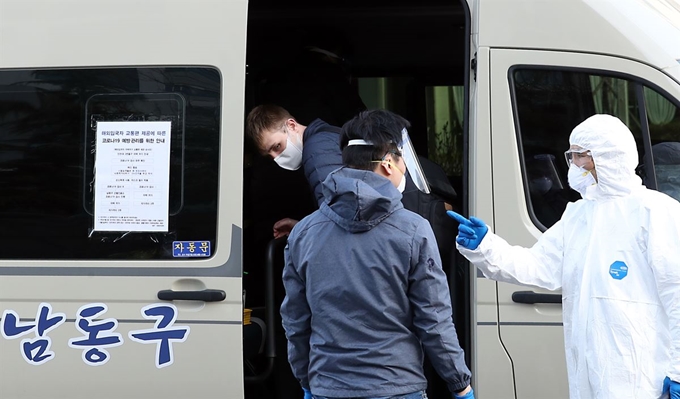 신종 코로나바이러스 감염증(코로나19) 해외 유입 억제를 위해 입국자 전용 버스 운행을 시작한 지난 1일 인천 남동구보건소 직원이 송도국제도시 거점 정류장에서 입국자들을 차량에 태우고 있다. 뉴시스