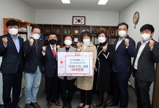 권연숙(왼쪽 5번째) 대구한국일보시민기자대학장과 시민기자 기수별 동기회 회장단이 7일 대구한국일보사에서 ‘코로나19 극복’ 성금을 이희정(4번째) 대구사회복지공동모금회 사무처장에게 전달하며 파이팅을 외치고 있다. 대구=윤창식기자 csyoon@hankookilbo.com