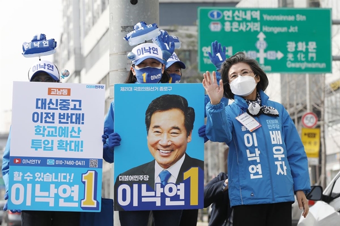 이낙연 더불어민주당 종로구 후보의 배우자 김숙희 여사가 6일 서울 서대문구 영천시장 앞 건널목에서 이 후보의 피켓과 나란히 서서 지지를 호소하며 손을 흔들고 있다. 뉴스1