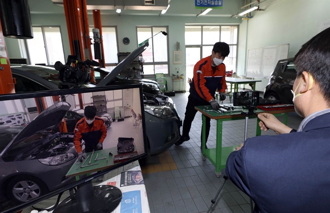 온라인 개학을 하루 앞둔 8일 서울 용산공고에서 자동차과 이상훈(왼쪽), 권기승 교사가 2인1조로 짝을 맞춰 원격수업용 동영상을 촬영하고 있다. 서재훈 기자 spring@hankookilbo.com