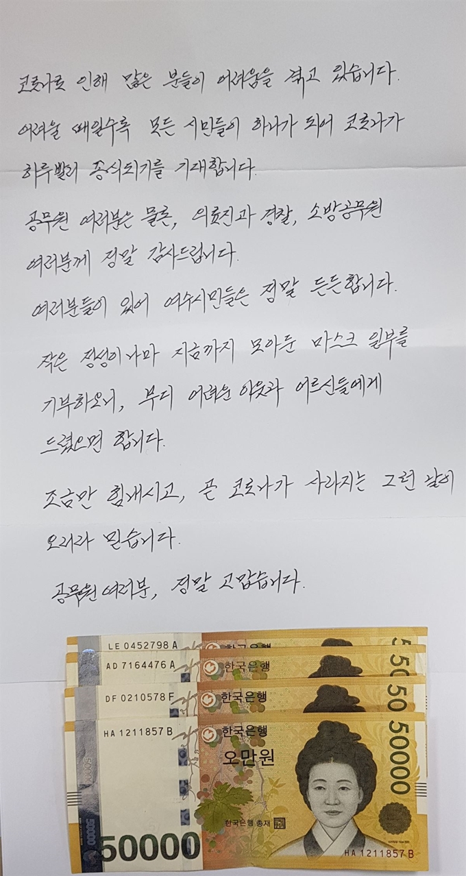 전남 여수시가 여서동주민센터에 익명의 기부자가 어려운 이웃을 위해 써달라며 마스크 48매와 현금 20만원을 두고 갔다고 8일 밝혔다. 사진은 익명의 기부자가 남긴 현금과 편지. 연합뉴스