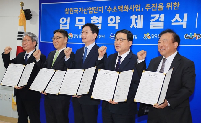 경남도는 9일 경남도청 소회의실에서 수소액화 실증 플랜트구축사업 공동 시행 주체인 창원시, 두산중공업 등과 업무협약을 체결했다. 왼쪽부터 이동찬 한국산업단지공단 경남지역본부장, 정연인 두산중공업 대표이사, 김경수 경남지사, 허성무 창원시장, 백정한 창원산업진흥원장 등 참석자들이 협약을 체결한 뒤 파이팅을 외치고 있다. 경남도 제공