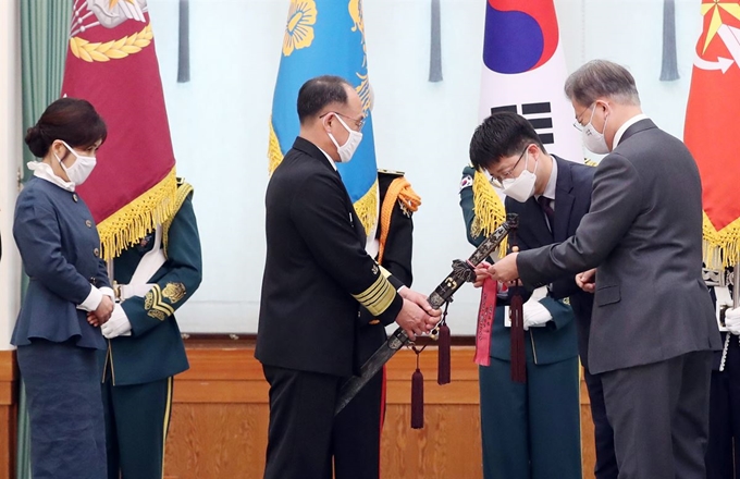 문재인 대통령이 10일 오후 청와대에서 부석종 해군참모총장의 진급 및 보직신고를 받은 후 삼정검(三精劍)에 수치(綬幟)를 달아주고 있다. 수치는 끈으로 된 깃발로 장성의 보직과 이름, 임명 날짜, 수여 당시 대통령 이름이 수놓아져 있다. 연합뉴스