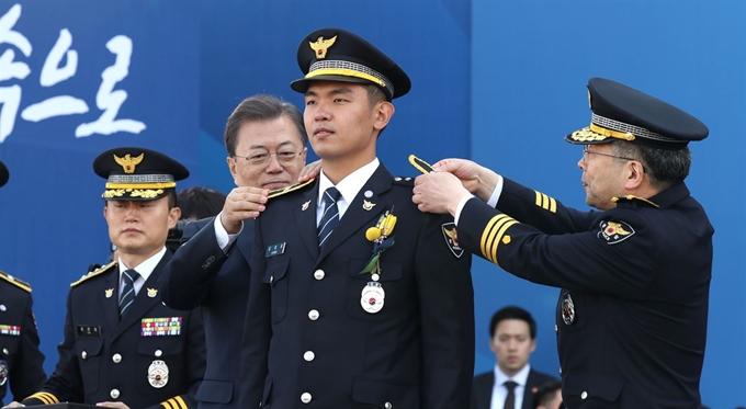 문재인 대통령이 지난 달 12일 충남 아산 경찰대학에서 열린 신임경찰 경위ㆍ경감 임용식에 참석해 민갑룡 경찰청장과 함께 계급장을 수여하고 있다. 왕태석 선임기자