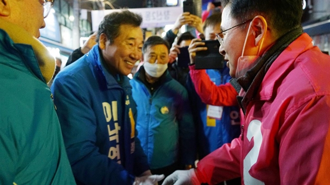 더불어민주당 서울 종로 이낙연 후보가 12일 서울 종로구 창신동 골목시장 상가방문 중 미래통합당 서울 종로 황교안 후보를 만나 인사를 나누고 있다. 연합뉴스