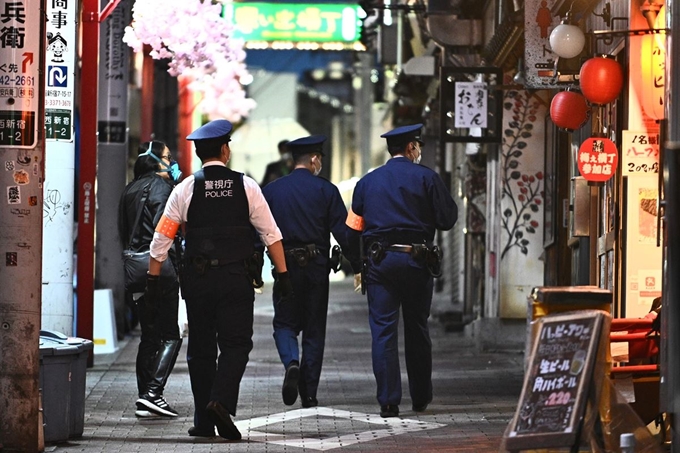 일본 경찰들이 12일 긴급사태가 선포된 도쿄 거리를 순찰하고 있다. 도쿄=AFP 연합뉴스