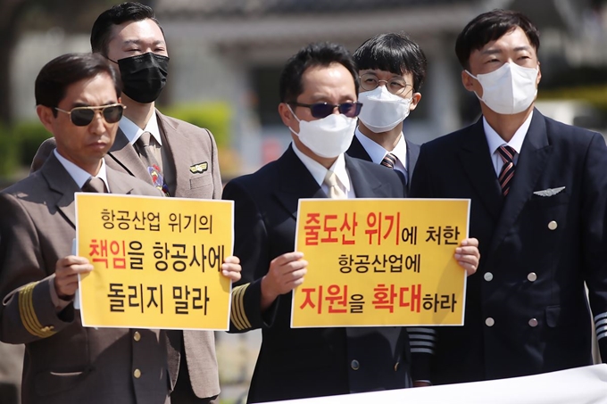 대한민국 조종사 노동조합 연맹과 전국연합노동조합연맹 소속 회원들이 14일 서울 청와대 분수대 앞에서 열린 '위기의 항공산업, 정부지원을 촉구하는 항공업계 노동조합 공동 기자회견'에서 손 팻말을 들고 있다. 연합뉴스