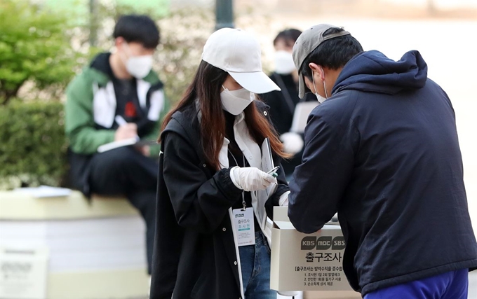 제21대 국회의원 선거일인 15일 오전 강원 춘천시 우석초등학교에 마련된 투표소 앞에서 투표를 마친 유권자가 출구조사에 응하고 있다. 연합뉴스