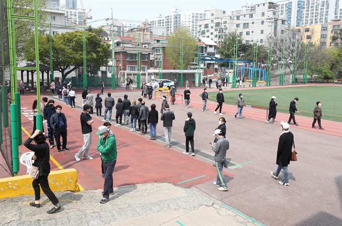 제21대 국회의원 선거일인 15일 오전 서울 동작구 상도1동 제1투표소가 마련된 강남초등학교에서 시민들이 투표를 하기 위해 길게 줄을 서 있다. 연합뉴스