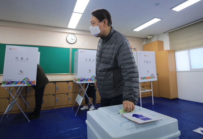 윤석열 검찰총장이 제21대 국회의원선거일인 15일 오전 서울 서초구 원명초등학교에 마련된 투표소에서 투표를 하고 있다. 2개월 여 만에 언론 카메라에 포착된 윤 총장은 이날 홀로 투표소를 찾아 마스크를 쓴 채 한 표를 행사했다. 뉴스1