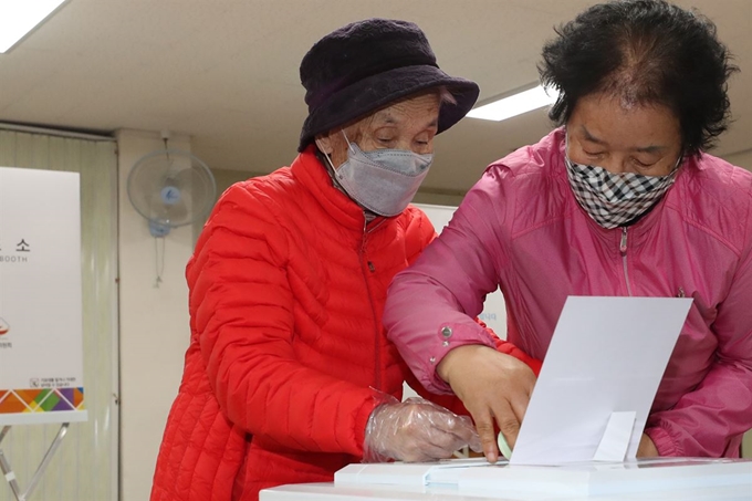 제21대 국회의원 선거일인 15일 광주 북구 문흥1동 행정복지센터에 마련된 투표소에서 박명순(왼쪽) 할머니가 며느리의 도움을 받아 투표에 참여하고 있다. 광주=연합뉴스